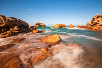 Rocks on beach against sky