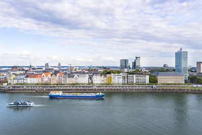 Boats in river against buildings in city