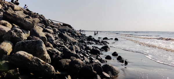 Rock formation on beach against clear sky