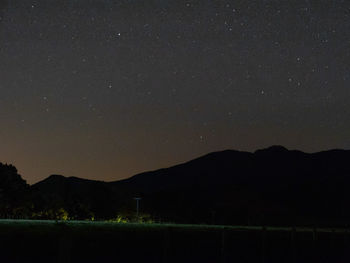 Scenic view of silhouette mountains against sky at night