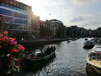 River amidst buildings in city against sky