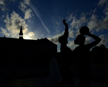 Silhouette people standing against sky