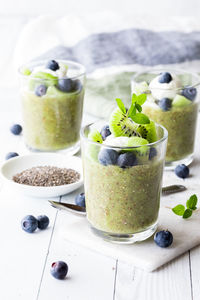 Kiwi chia puddings topped with vanilla yogurt and blueberries.