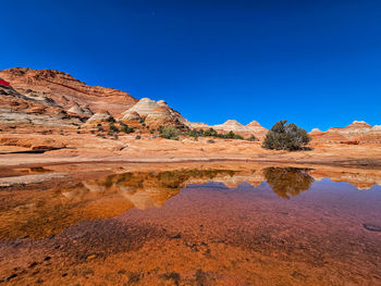 Scenic view of desert against clear blue sky