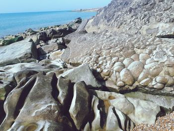 Rocks on beach against sky