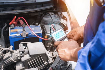 Midsection of man repairing car