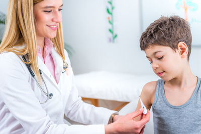 Female doctor examining boy at clinic