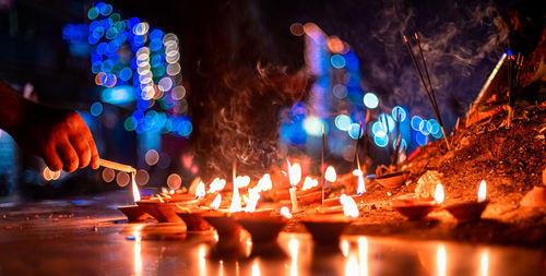 Panoramic view of illuminated candles in temple at night