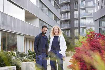 Male and female worker in front of residential building