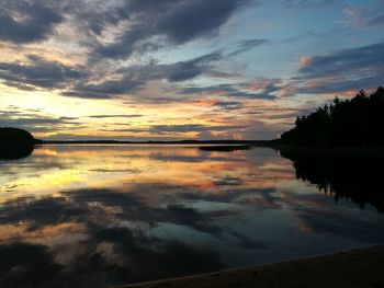 Scenic view of calm lake against cloudy sky