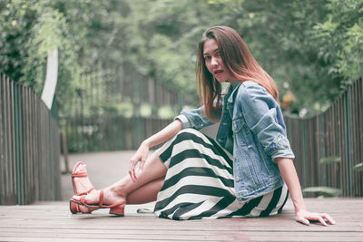 Full length of woman sitting outdoors