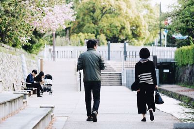 Rear view of woman standing on footpath