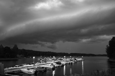 Sailboats moored at harbor against sky