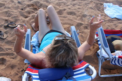 Rear view of woman sitting on beach