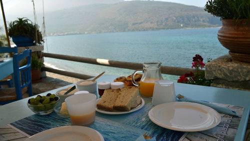 Close-up of breakfast on table against sea