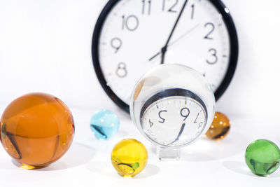 Close-up of clock on table against white background