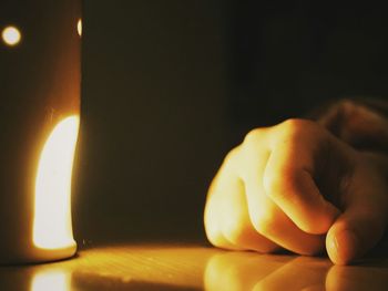 Close-up of lit candle in the dark