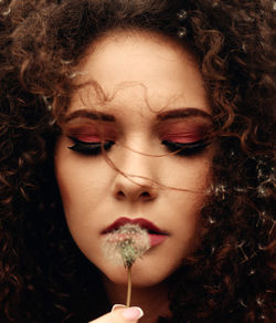 Close-up of beautiful woman holding dandelion