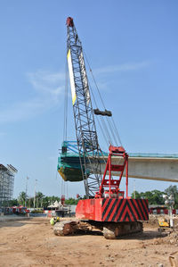 Cranes at construction site against sky