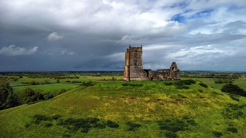 Old ruin building on field against sky