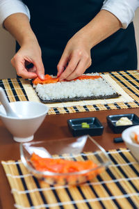 Midsection of man holding sushi