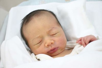 Close-up of baby sleeping on bed