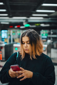 Mid adult woman using mobile phone in bus