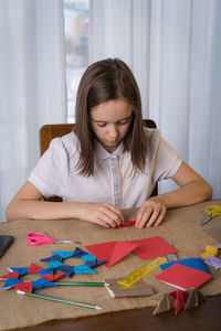 A beautiful teenage girl makes origami