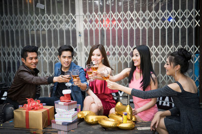 Friends toasting drinks during party