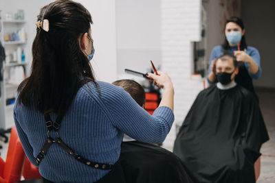 Barber shops, hair salons shutting down, second lockdown. hairdresser in face mask 