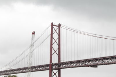 Low angle view of suspension bridge against sky