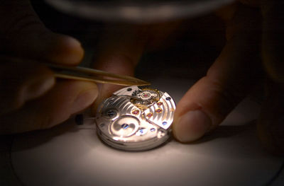 Close-up of hands working on wristwatch