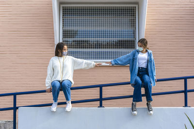 Full length of young man standing on railing