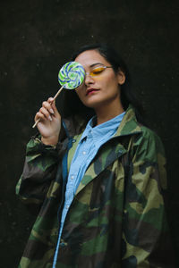 Smiling young woman with candy outdoors