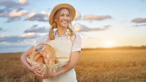 Portrait of a smiling young woman standing on field