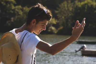 Teenage boy with hat in the river