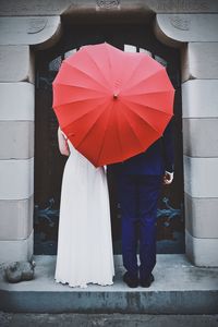 Low section of people holding umbrella