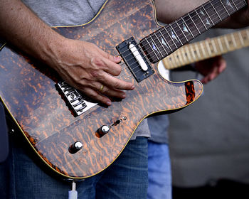 Midsection of man playing guitar