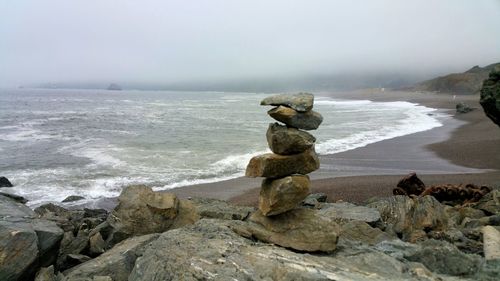 Rocks on beach against sky