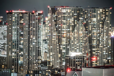 Illuminated buildings in city against sky at night