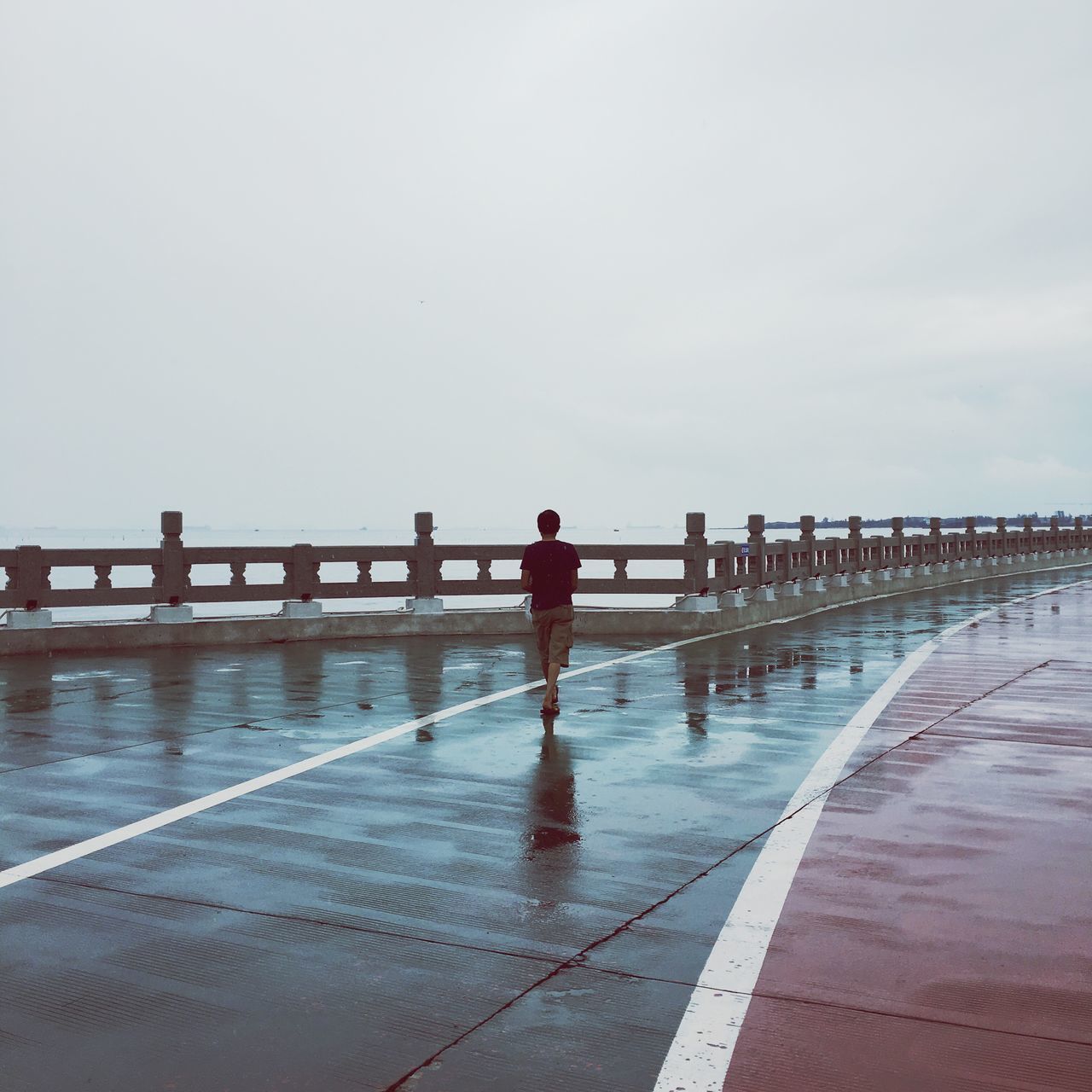 water, sea, incidental people, pier, clear sky, vacations, railing, sky, day, tranquil scene, tourism, tranquility, promenade, calm, shore, outdoors, nature, person, ocean