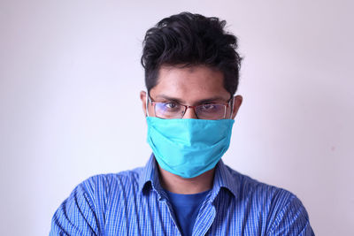 Portrait of man with mask against pink background