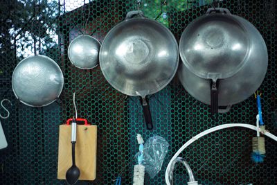 Close-up of kitchen utensils hanging on metal grate