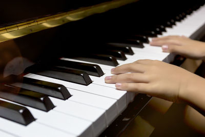 Close-up of hands playing piano