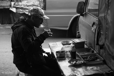 Man drinking tea while sitting on table