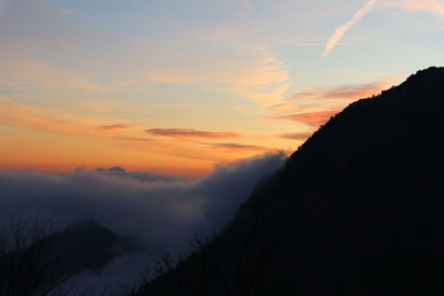 Scenic view of silhouette mountains against sky at sunset