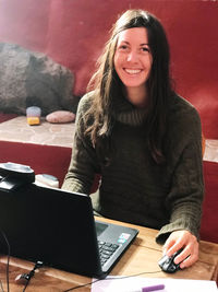 Portrait of a smiling young woman using mobile phone