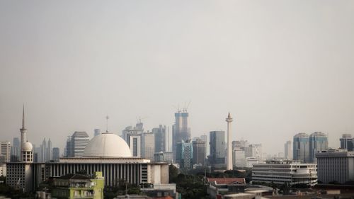 Buildings in city against clear sky