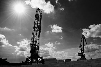 Low angle view of crane at construction site against sky