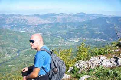 Man standing on mountain against mountains